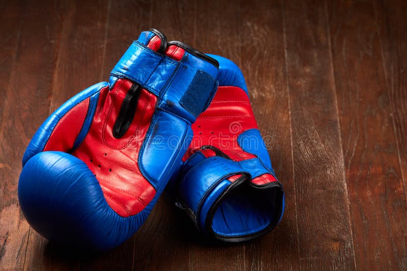 Paare der blauen und roten Boxhandschuhe, die auf dem braunen Holztisch liegen stockfoto Paare der blauen und roten Boxhandschuhe, die auf dem braunen Holztisch liegen stockfoto