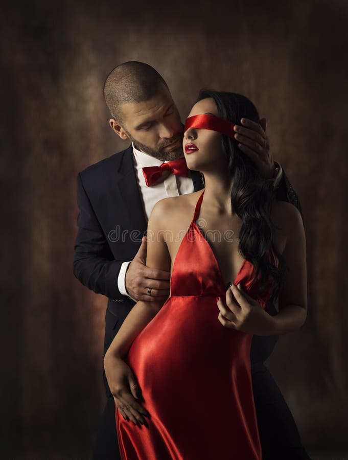 Paare in der Liebe, sexy Mode-Frau und Mann, Mädchen mit rotem Band auf den Augen, die Freund in der Klage, Zauber vorbildliches
