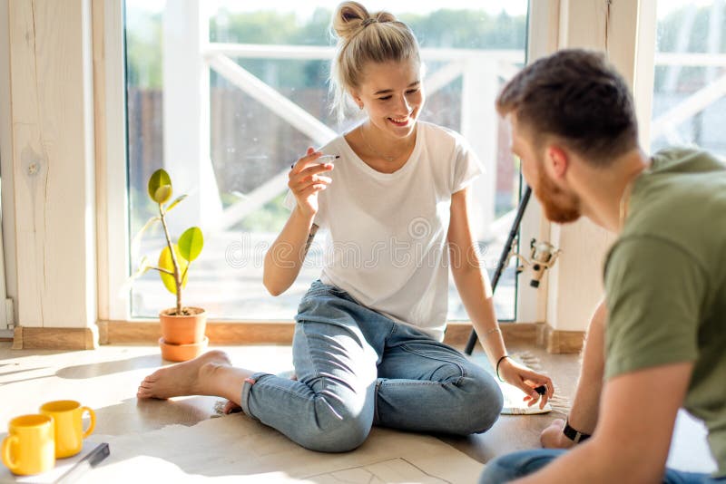 Paare, die Pläne von ihnen neues Haus schauen Planende Innenarchitektur stockbild Paare, die Pläne von ihnen neues Haus schauen Planende Innenarchitektur stockbild