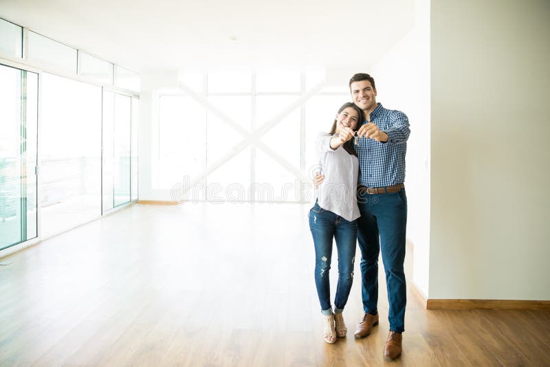 Full length of mid adult couple feeling happy about buying a new house. Full length of mid adult couple feeling happy about buying a new house