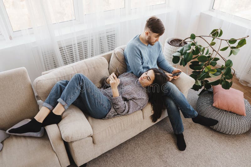 Paare im Wohnzimmer besessen gewesen mit Smartphones lizenzfreies stockbild Paare im Wohnzimmer besessen gewesen mit Smartphones lizenzfreies stockbild