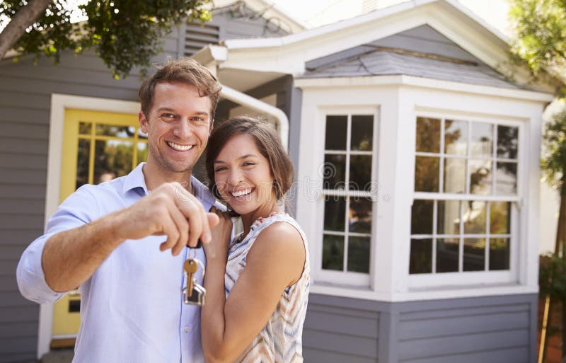 Paare mit den Schlüsseln, die äußeres neues Haus stehen lizenzfreie stockfotos Paare mit den Schlüsseln, die äußeres neues Haus stehen lizenzfreie stockfotos