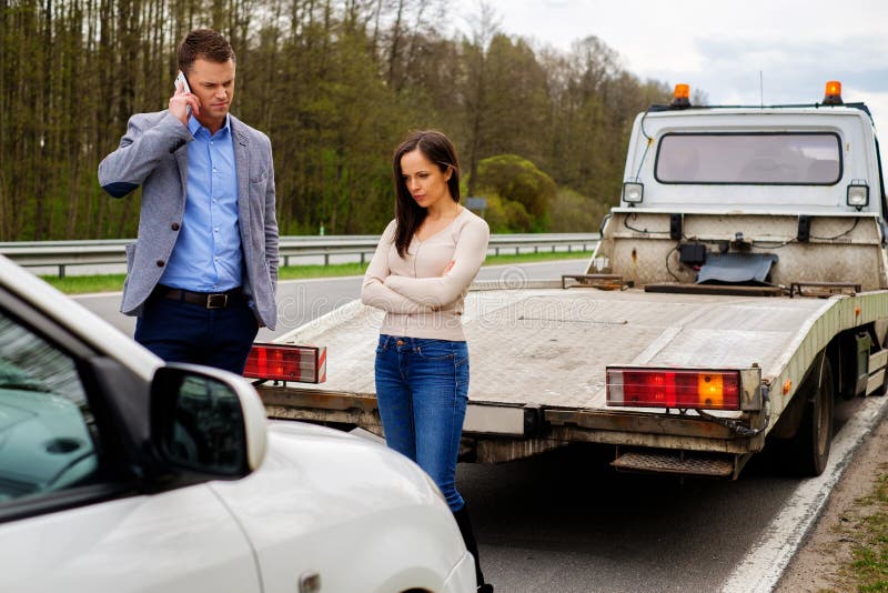Paare nähern sich defektem Auto auf einem Straßenrand lizenzfreies stockbild Paare nähern sich defektem Auto auf einem Straßenrand lizenzfreies stockbild