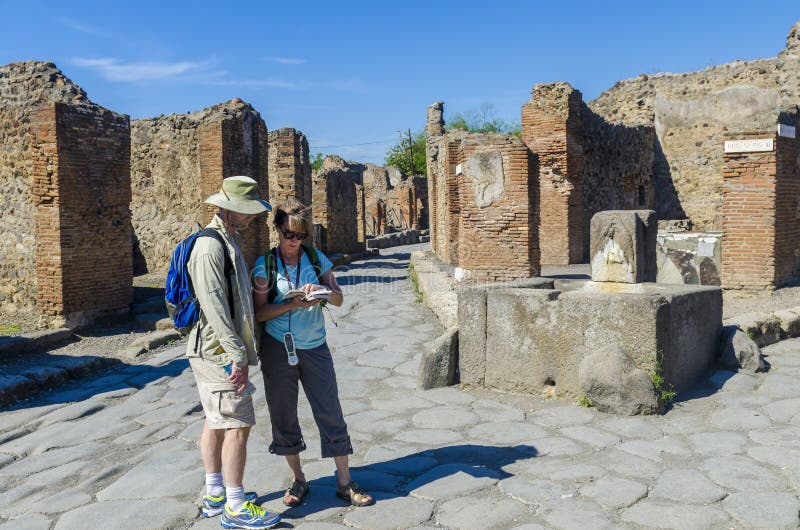 Paare von den Touristen, welche die Ruinen in Pompeji besuchen lizenzfreie stockfotografie Paare von den Touristen, welche die Ruinen in Pompeji besuchen lizenzfreie stockfotografie