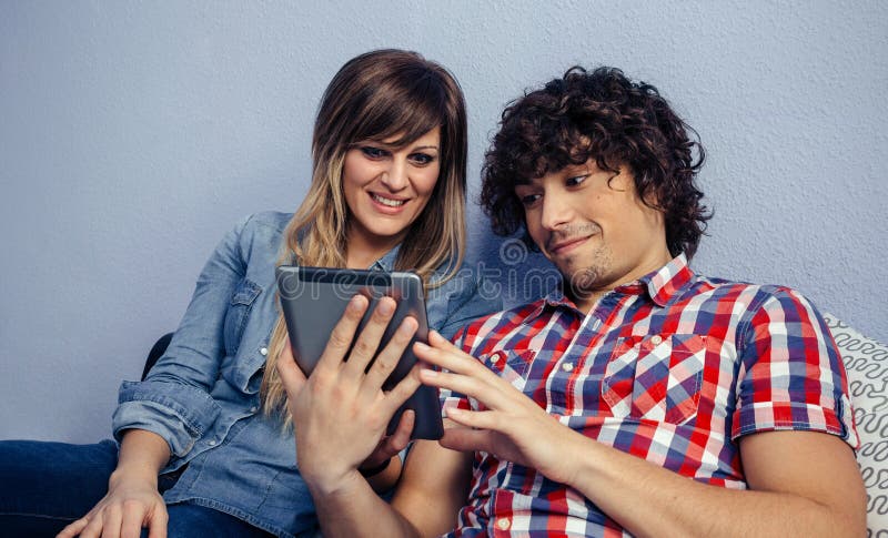 Paare, welche die Tablette betrachten stockbild Paare, welche die Tablette betrachten stockbild