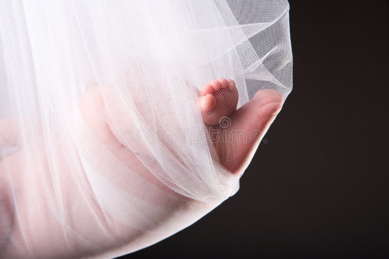 Stork Baby Package. 15 days old newborn baby girl carried in white cloth. Stork Baby Package. 15 days old newborn baby girl carried in white cloth