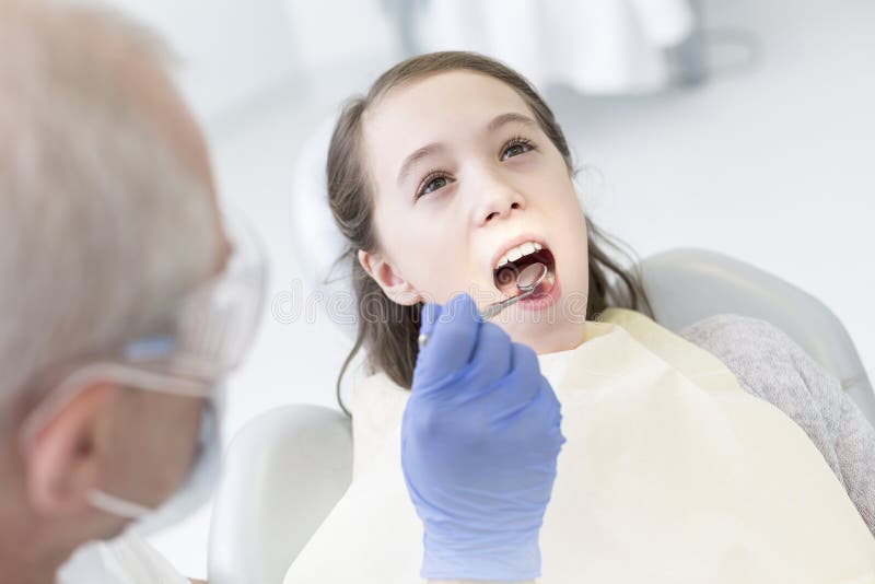 Paciente de exame do dentista com a boca aberta na clínica dental