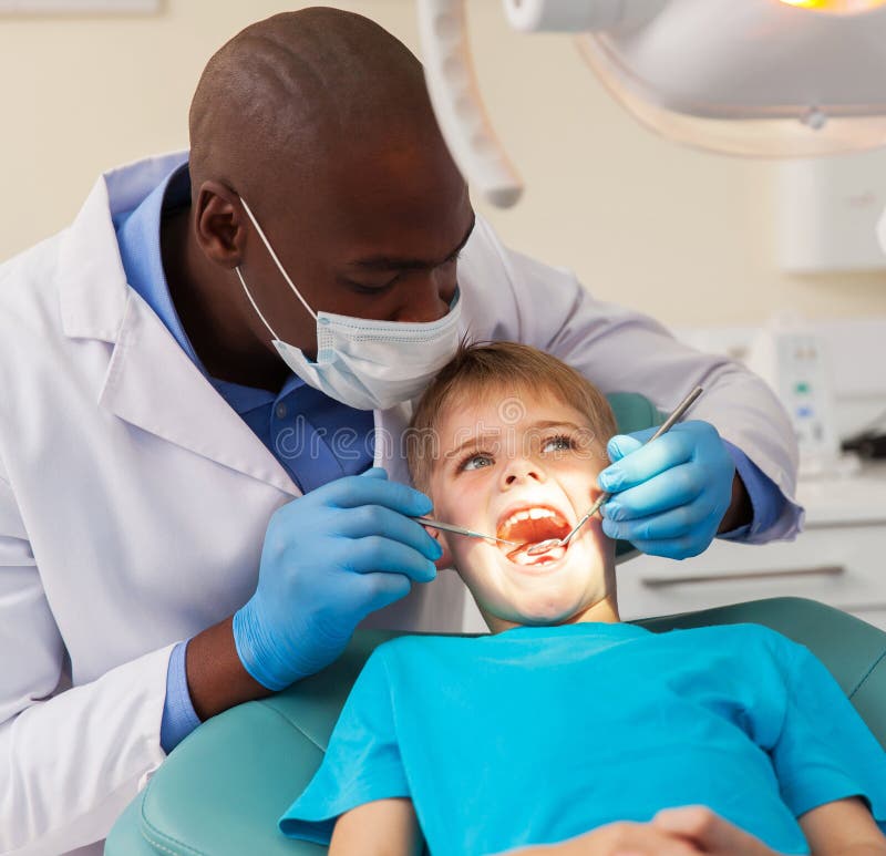 Paciente de trabalho do dentista africano imagem de stock Paciente de trabalho do dentista africano imagem de stock