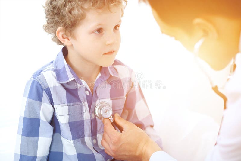Paciente del doctor y del niño El médico examina al niño pequeño por el estetoscopio Concepto de la terapia del ` s de la medicin foto de archivo Paciente del doctor y del niño El médico examina al niño pequeño por el estetoscopio Concepto de la terapia del ` s de la medicin foto de archivo