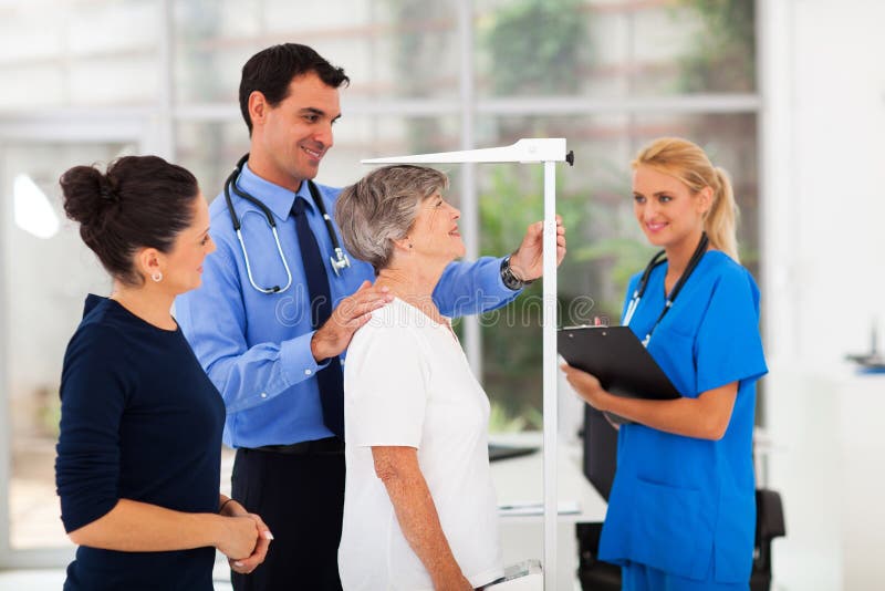 General practitioner measuring senior patient's height in office. General practitioner measuring senior patient's height in office