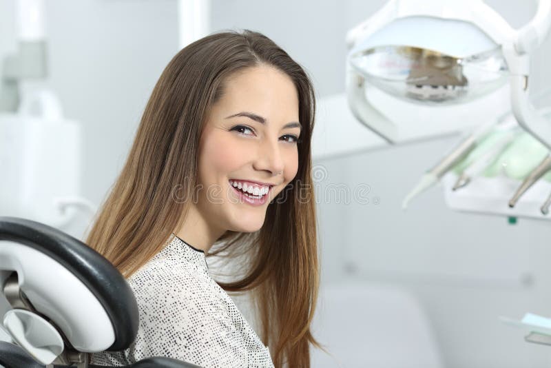 Paciente do dentista que mostra o sorriso perfeito após o tratamento