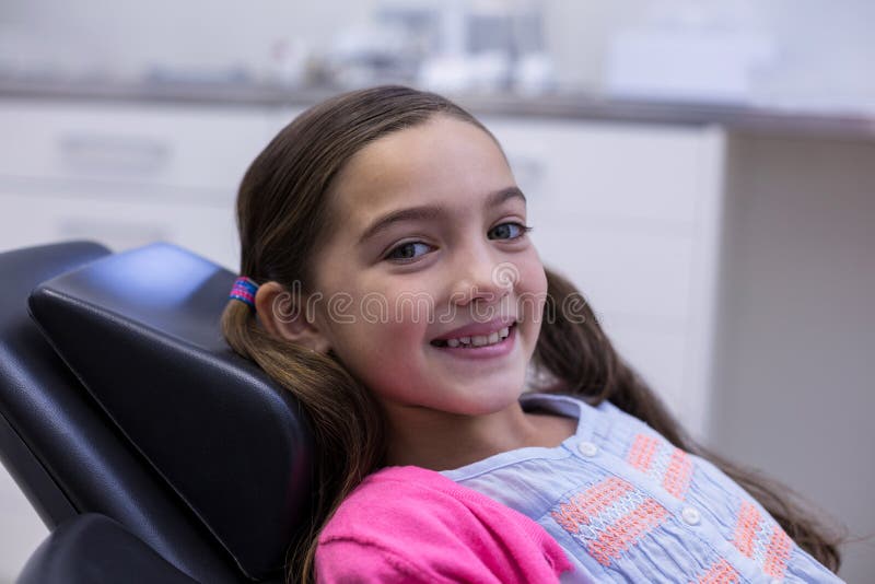 Portrait of smiling young patient sitting on dentists chair in dental clinic. Portrait of smiling young patient sitting on dentists chair in dental clinic