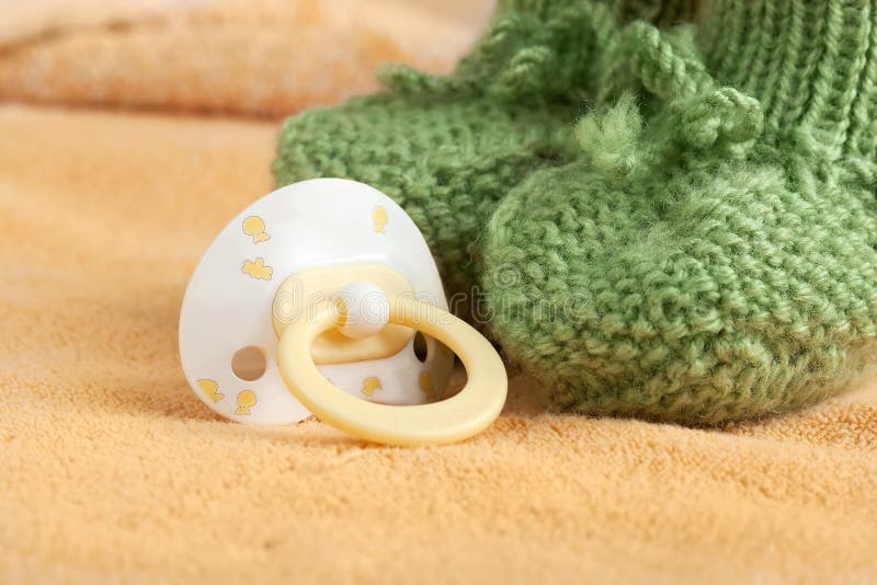 Pacifier and the baby booty on a blanket (manually focused on pacifier ring)