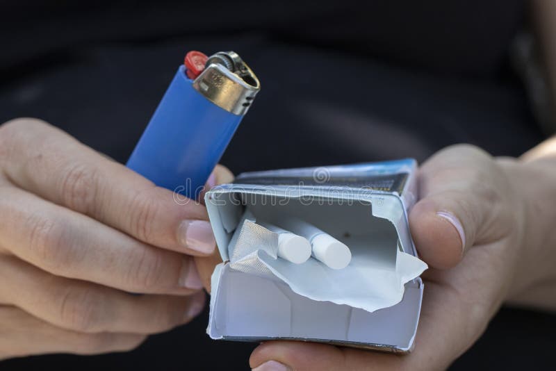A Pack of Cigarettes and a Lighter in Hands Stock Photo Image of