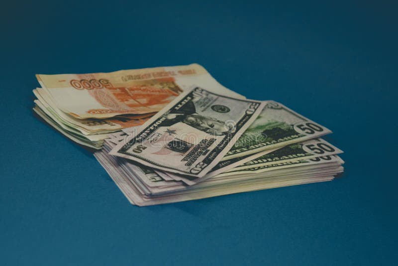a pack of Russian rubles and dollars. two wads of money on a blue background. wealth of opportunity. success royalty free stock images a pack of Russian rubles and dollars. two wads of money on a blue background. wealth of opportunity. success royalty free stock images