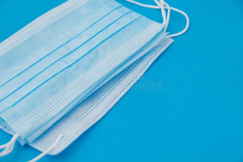 Pack of Several Blue Medical Masks Lies on Blue Background Stock Image