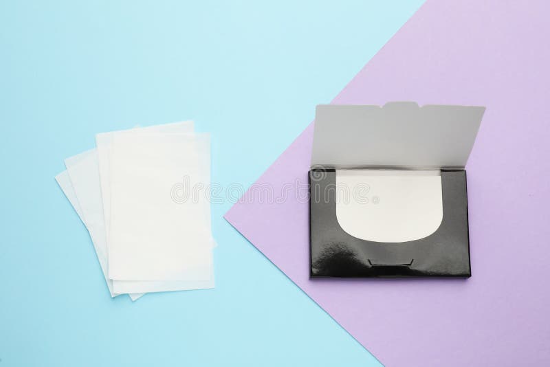 Package with facial oil blotting tissues on color background, flat lay. Mattifying wipes royalty free stock image