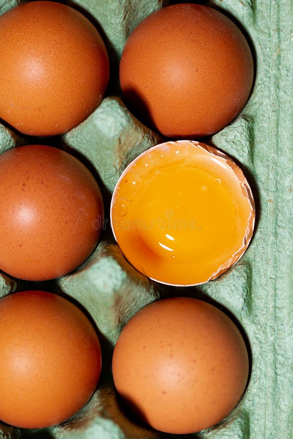 Package of Fresh Whole Chicken Eggs and One Broken Egg, Closeup Stock