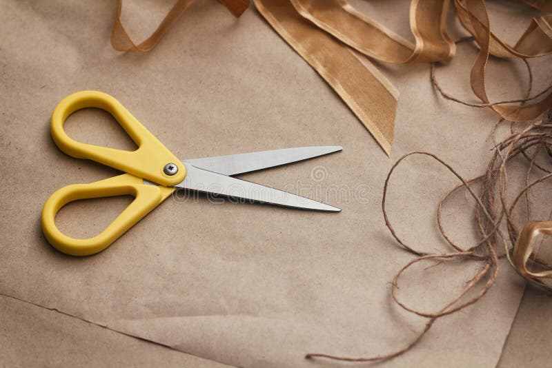 Packaging Process. Presents Wrapping. Yellow Scissors, Ribbons, Hemp Strings and Threads, Brown