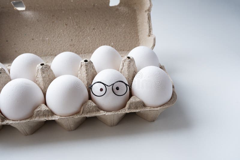 Packing White Eggs in a Cardboard Box. One Egg in Glasses Stock Photo