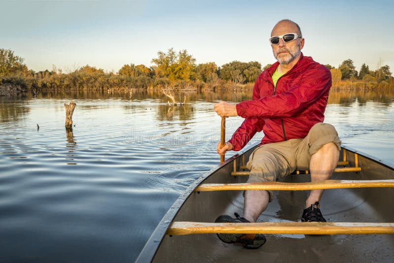 Paddling canoe on calm lake