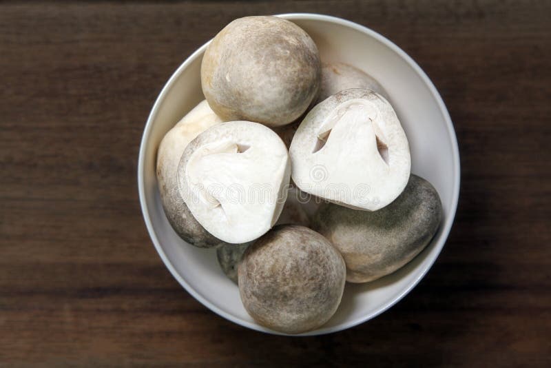 Paddy straw mushroom on wooden background. royalty free stock image