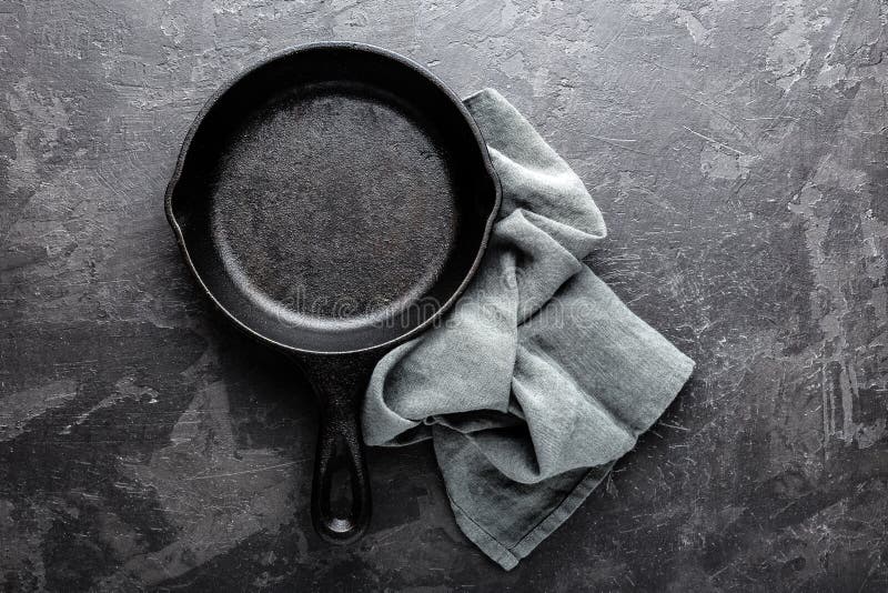 Padella vuota del ghisa su fondo culinario grigio scuro, vista da sopra