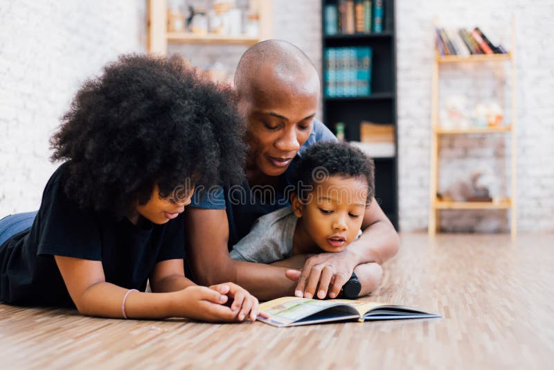 Padre afroamericano che legge una storia della favola di fiaba per il bambino