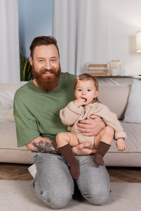 Padre allegro e tatuato che tiene in braccio la bambina fotografia stock libera da diritti