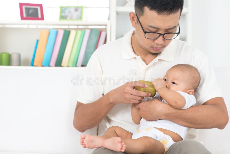 Padre che allatta con il biberon bambino fotografie stock Padre che allatta con il biberon bambino fotografie stock