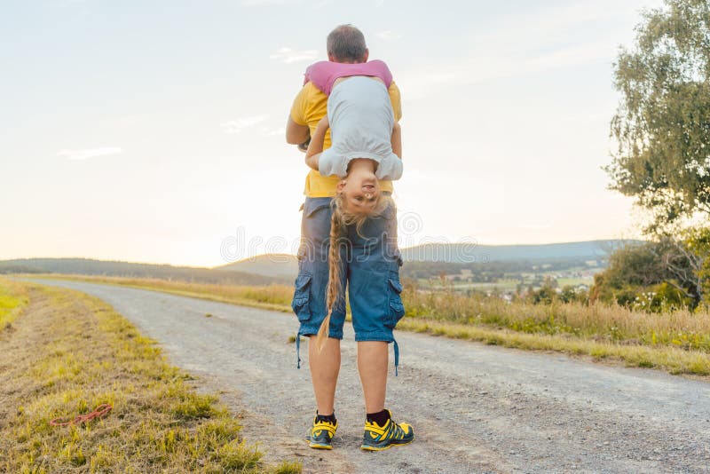 Padre che porta il suo a due vie della figlia di estate fotografia stock Padre che porta il suo a due vie della figlia di estate fotografia stock