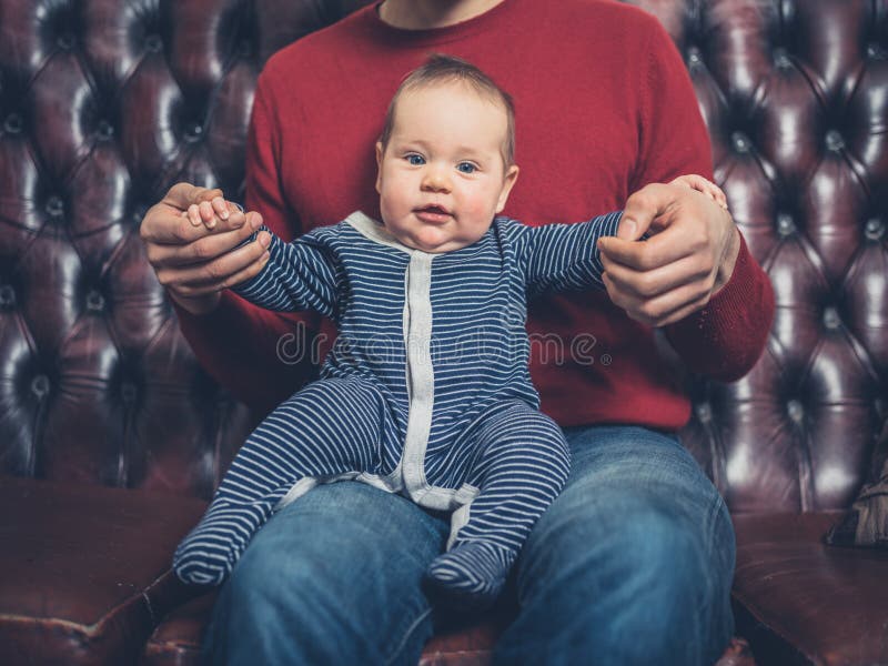 Padre con bebé en el sofá foto de archivo libre de regalías