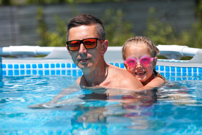 Padre Con Gafas De Sol Nada En La Piscina Con Su Hija. Padre Y Niña Pequeña  Nadando En La Piscina. Un Hombre Feliz Imagen de archivo - Imagen de padre,  poco: 221017929