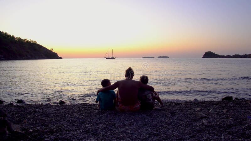 Padre con hijos en el mar al amanecer metrajes