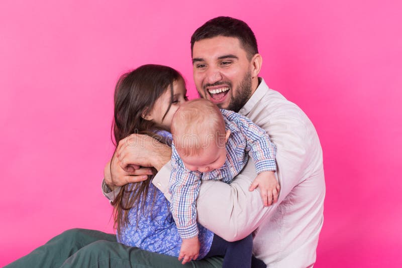 Padre con i bambini divertendosi sul fondo rosa immagini stock libere da diritti Padre con i bambini divertendosi sul fondo rosa immagini stock libere da diritti