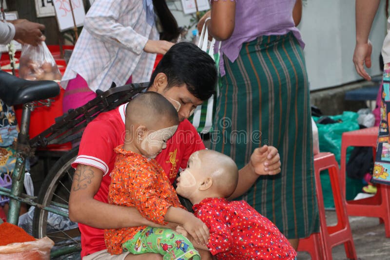 Padre de Myanmese y 2 niños con el polvo de Myanmar del thanakha en sus caras, jugando la diversión feliz junto en el mercado foto de archivo libre de regalías Padre de Myanmese y 2 niños con el polvo de Myanmar del thanakha en sus caras, jugando la diversión feliz junto en el mercado foto de archivo libre de regalías