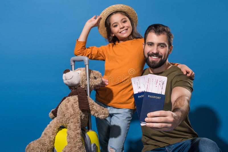 padre e figlia con i passaporti ed i biglietti che vanno sulla vacanza