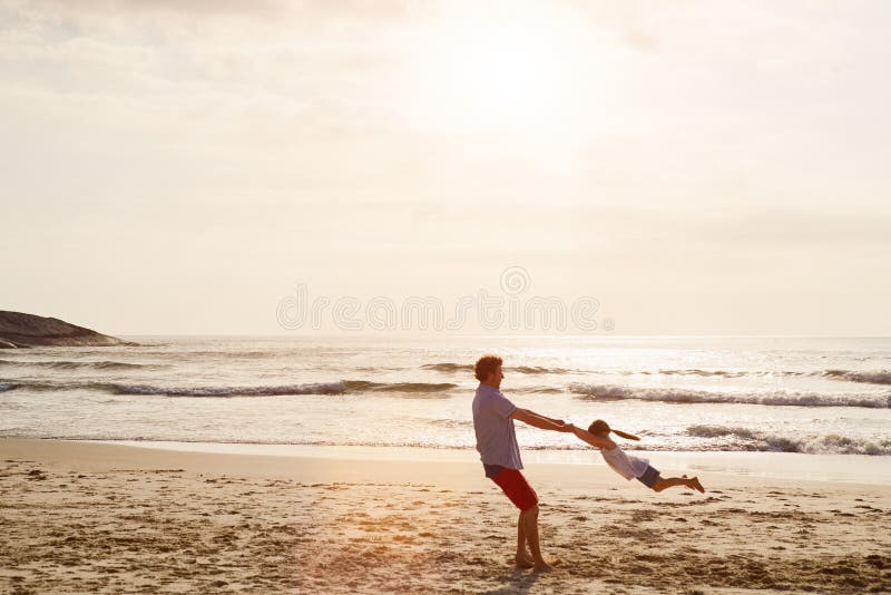 Padre e figlio all'aperto in spiaggia per giocare e legarsi in vacanza. famiglia spaziale e papà immagini stock