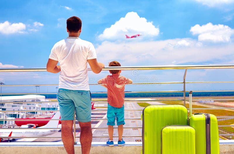 Padre e figlio pronti per le vacanze estive, mentre aspettando imbarco nell'aeroporto internazionale fotografia stock Padre e figlio pronti per le vacanze estive, mentre aspettando imbarco nell'aeroporto internazionale fotografia stock
