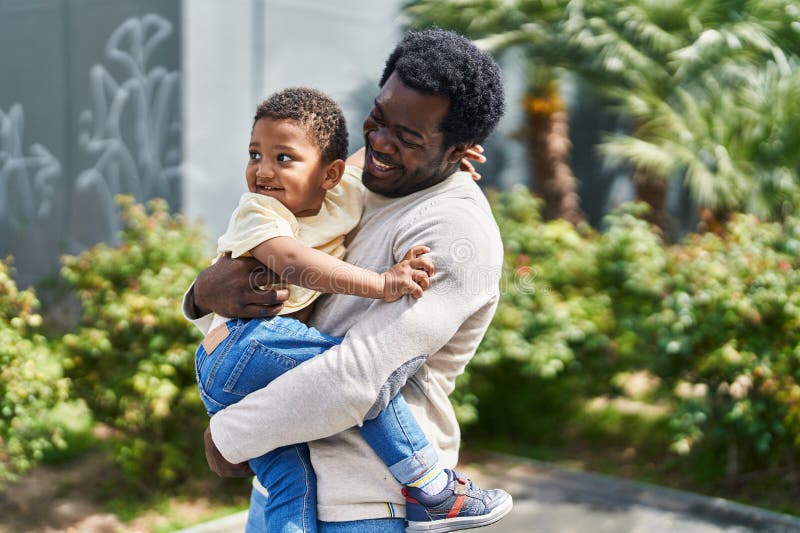 Padre e figlio che si abbracciano al parco giochi fotografie stock libere da diritti