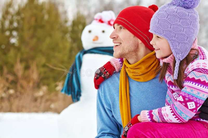 Padre e hija con el muñeco de nieve foto de archivo Padre e hija con el muñeco de nieve foto de archivo