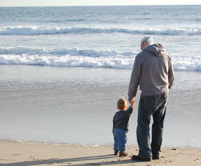 Father and son walking on the beach and enjoying time together. Father and son walking on the beach and enjoying time together