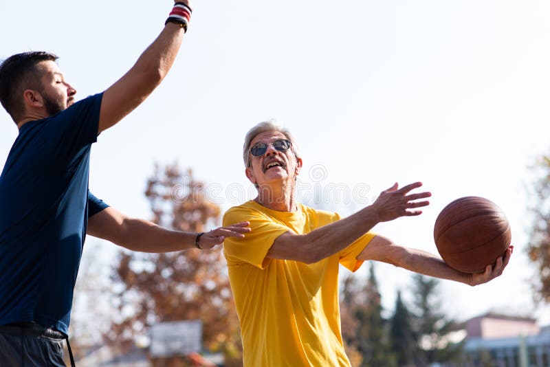 Padre e hijo que juegan a baloncesto en el parque imagen de archivo libre de regalías Padre e hijo que juegan a baloncesto en el parque imagen de archivo libre de regalías