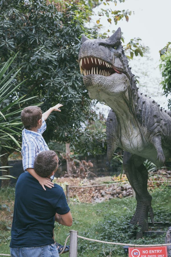Padre e hijo que juegan en el parque de Dino de la aventura foto de archivo libre de regalías Padre e hijo que juegan en el parque de Dino de la aventura foto de archivo libre de regalías