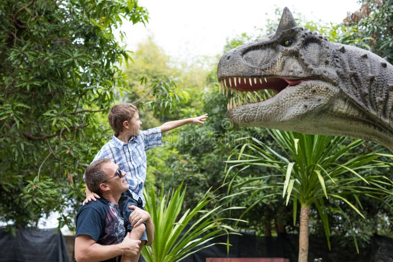 Padre e hijo que juegan en el parque de Dino de la aventura fotografía de archivo libre de regalías Padre e hijo que juegan en el parque de Dino de la aventura fotografía de archivo libre de regalías