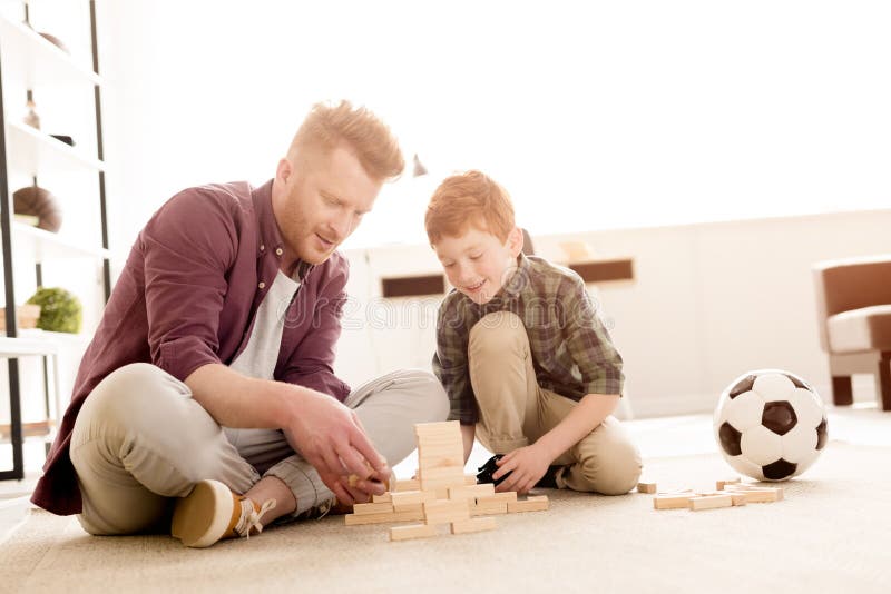 Padre e hijo sonrientes que juegan con los bloques de madera imágenes de archivo libres de regalías