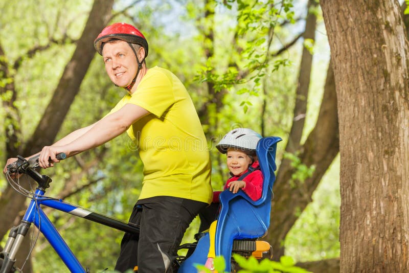 Padre felice e sua piccola la figlia che guidano una bici immagine stock libera da diritti Padre felice e sua piccola la figlia che guidano una bici immagine stock libera da diritti