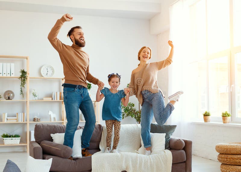 a happy family mother father and child daughter dancing at home. a happy family mother father and child daughter dancing at home