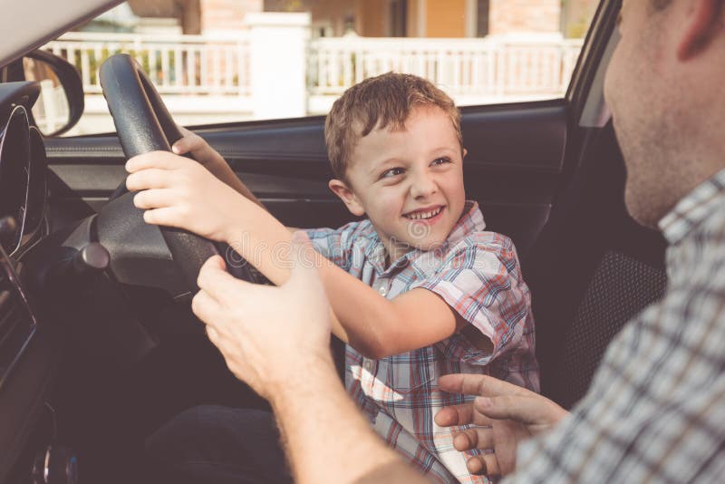 Padre feliz e hijo que se sientan en el coche en el tiempo del día fotos de archivo Padre feliz e hijo que se sientan en el coche en el tiempo del día fotos de archivo
