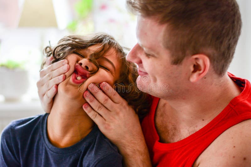 Padre feliz que juega con el muchacho en cocina fotografía de archivo libre de regalías Padre feliz que juega con el muchacho en cocina fotografía de archivo libre de regalías